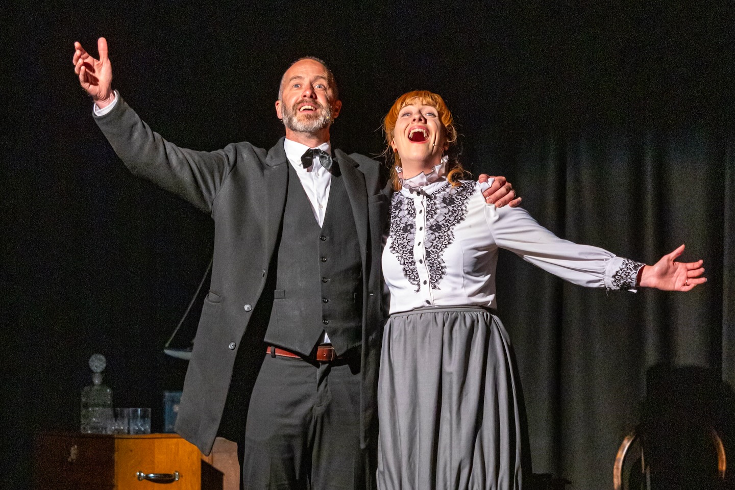 A pair of actors sing the finale of a duet