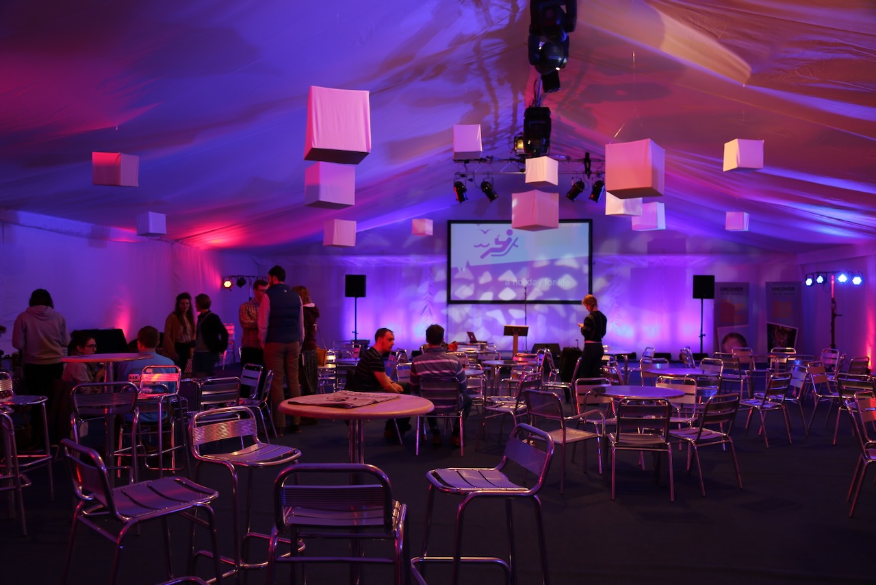 Evening meeting with purple lighting, chrome chairs and floating cubes